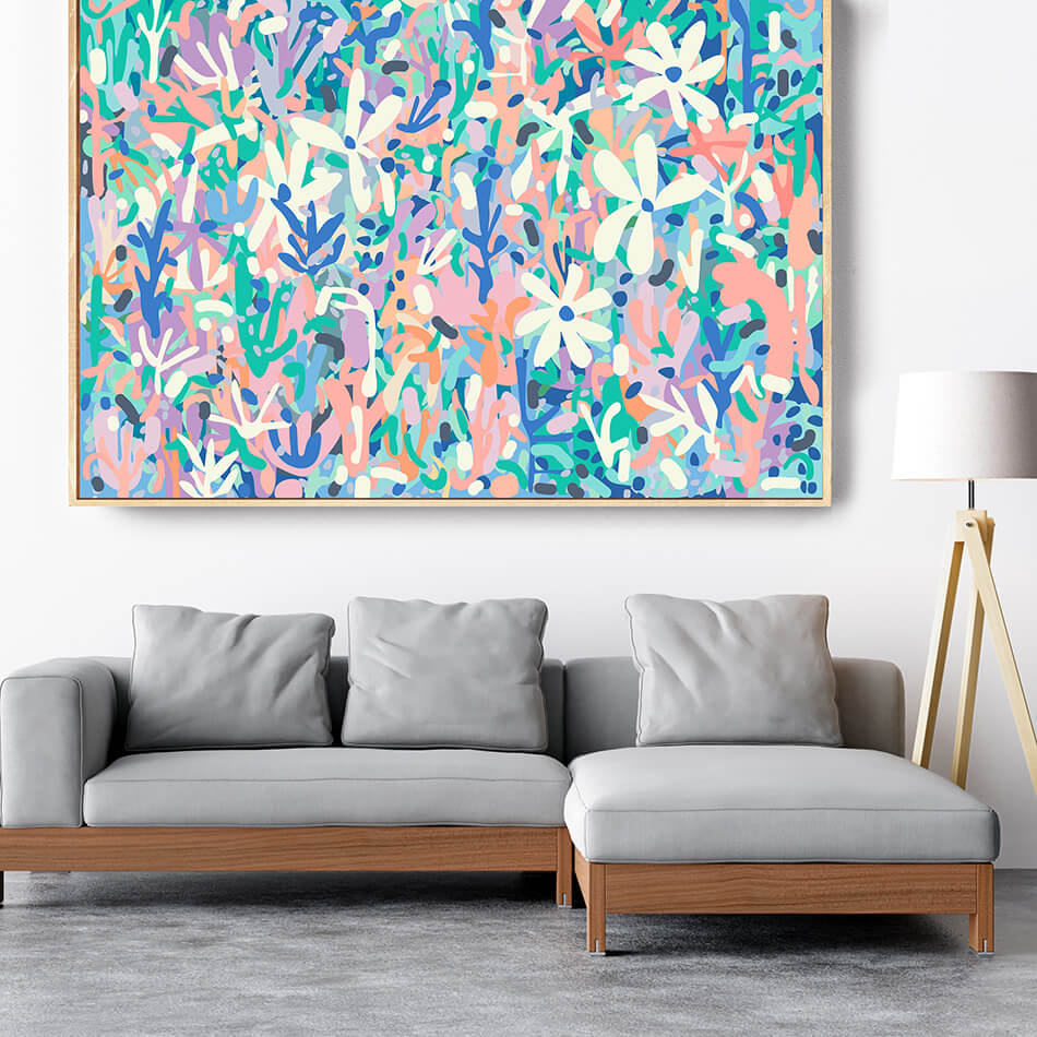 Gray sectional sofa with wooden frame in front of a colorful abstract painting on a white wall.